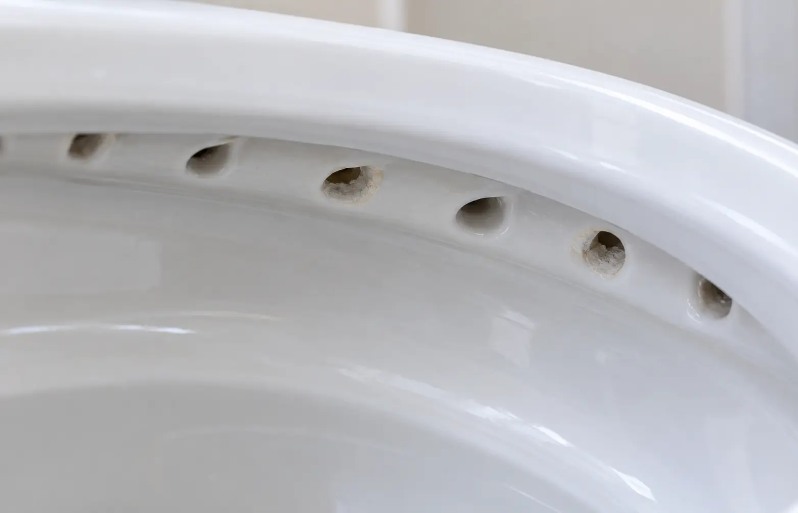 Mineral buildup restricting toilet rim holes and weakening the flush